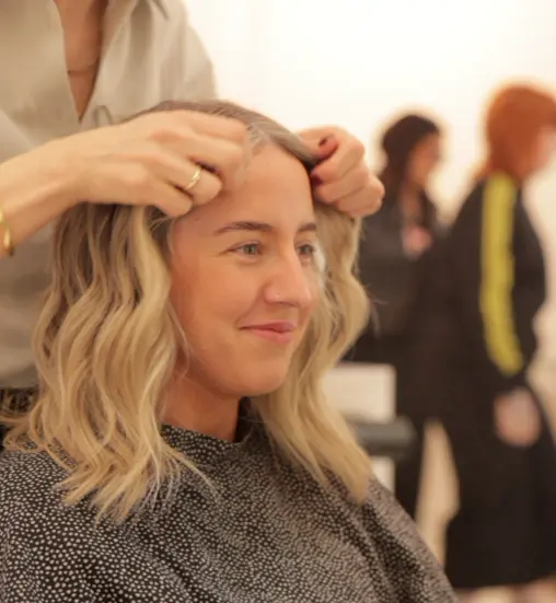 Hair stylist applying grey blending to blonde haired client